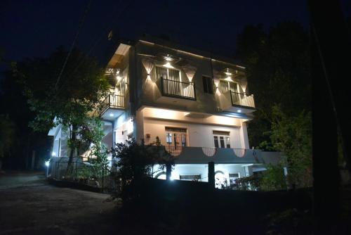 un gran edificio blanco con luces encendidas por la noche en Everdew Kandy en Kandy