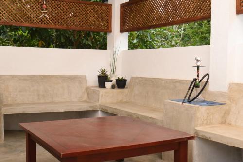 a living room with benches and a table at Everdew Kandy in Kandy