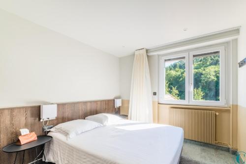 sypialnia z dużym łóżkiem i oknem w obiekcie Hotel Restaurant au Floridor w mieście Thann