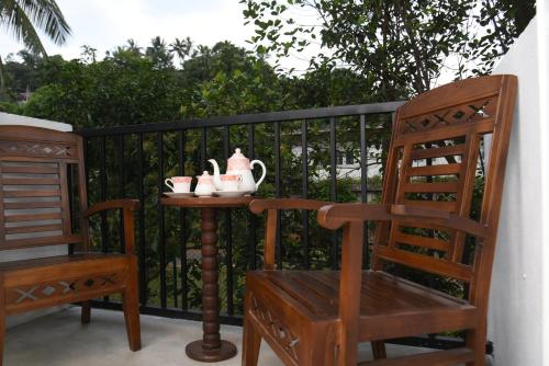a table with two chairs and a tea set on a balcony at Everdew Kandy in Kandy