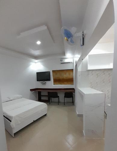 a bedroom with a bed and a desk and a tv at Studio NDOUR Castors in Dakar