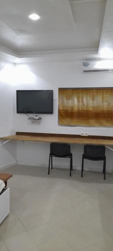 a room with two chairs and a television on a wall at Studio NDOUR Castors in Dakar
