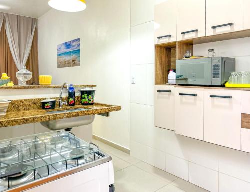 a kitchen with white cabinets and a counter top at Casa c WiFi e vista para o mar-Barra de São João RJ in Casimiro de Abreu