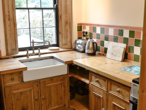 a kitchen with a sink and a counter top at Langcliffe Lock Cottage in Stainforth