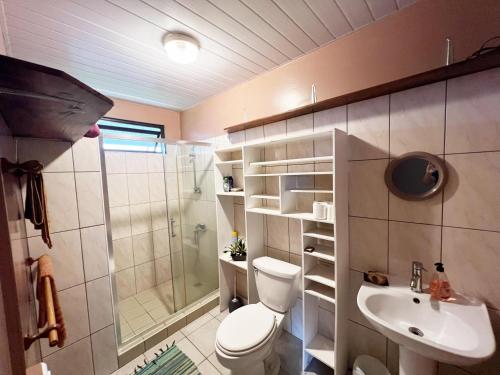 La salle de bains est pourvue de toilettes, d'une douche et d'un lavabo. dans l'établissement TAHITI - Fare Matavai Hoe, à Taravao