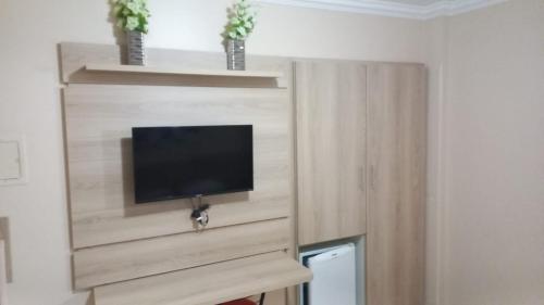 um quarto com uma televisão num armário de madeira em diRoma Rio Quente - Para Voce se Sentir em Casa :D em Rio Quente