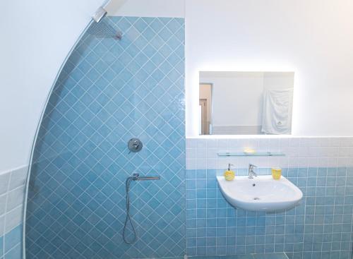 ミノーリにあるSeashell apartmentの青いタイル張りのバスルーム(シンク、鏡付)