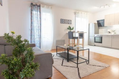 een woonkamer met een bank en een tafel bij Le Chaleureux-T2-47m2-Disney in Serris