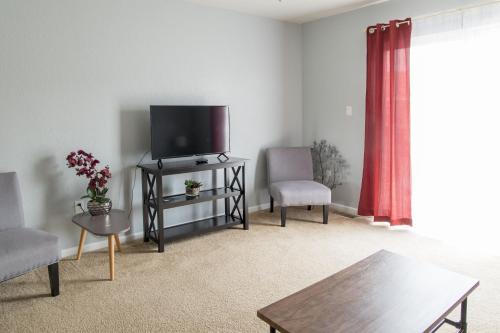 a living room with a flat screen tv and two chairs at King Bed, TV's in Every Bedroom, Bring Your Pets! KMS1309 in Manhattan