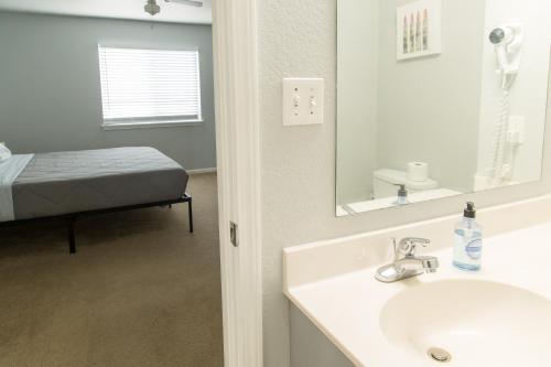 a bathroom with a sink and a mirror and a bed at King Bed, TV's in Every Bedroom, Bring Your Pets! KMS1309 in Manhattan