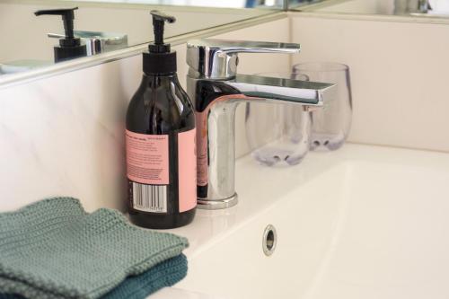 - Botella de vino junto al lavabo del baño en Gem bed and breakfast, en Christchurch