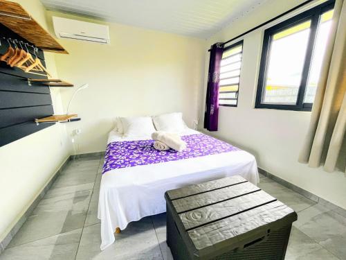 Habitación pequeña con cama y banco en TAHITI - Fare Matavai Toru, en Taravao