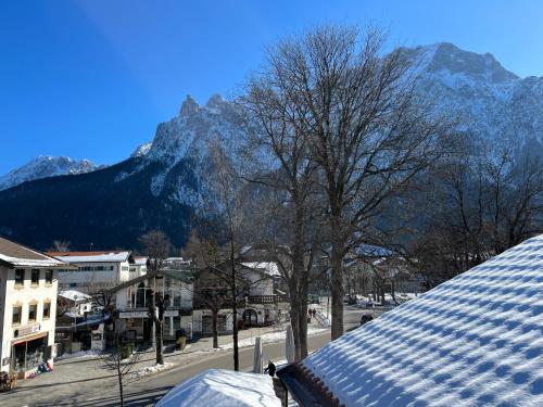 a snow covered city with a mountain in the background at Ferienwohnung Seidl Wohnung Violine in Mittenwald
