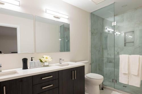 a bathroom with a sink and a glass shower at Luxury Niagara 3 Bdr Townhouse /Garage in Niagara Falls