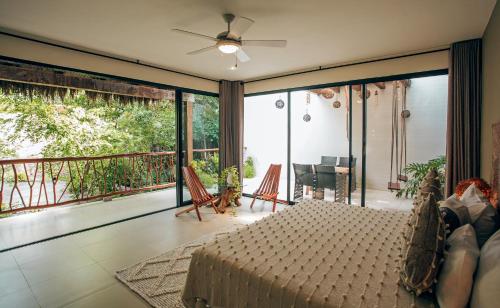 a living room with a bed and a balcony at Orchid House Tulum Jungle in Tulum
