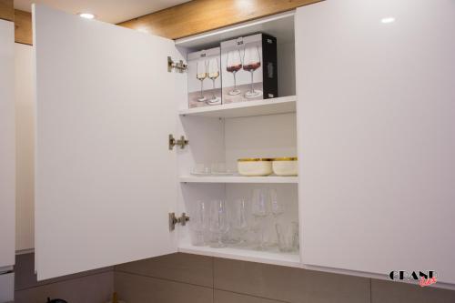 un meuble de cuisine avec des objets en verre dans l'établissement GRAND LUX Apartment, à Doboj