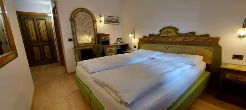 a bedroom with a large bed with a wooden headboard at Garnì Stella Alpina in Canazei