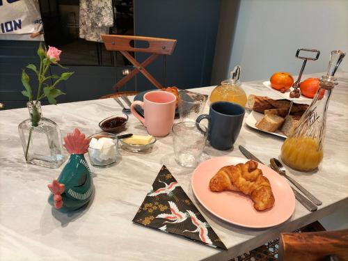 una mesa con un plato de pasteles. en Gîte l'Eden à l'Est en Colombey-les-deux-Églises