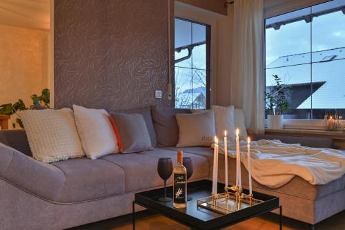 a living room with a couch with candles on a table at Ferienwohnung #TIMEOUT in Pfronten