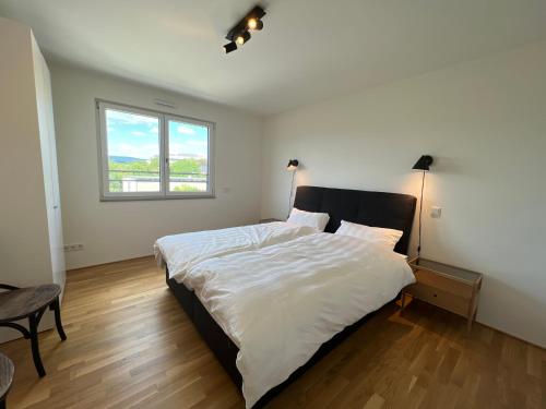- une chambre avec un grand lit et une fenêtre dans l'établissement Penthouse I Dachterrasse I Tiefgaragenstellplatz I nahe Bhf, JoHo, Brita-Arena, à Wiesbaden