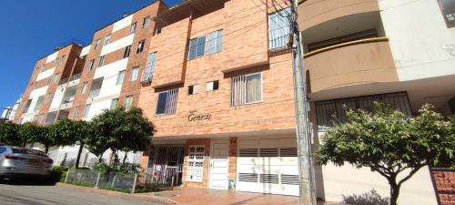 un gran edificio de ladrillo con un coche aparcado delante de él en Moderno y Confortable San Alonso en Bucaramanga