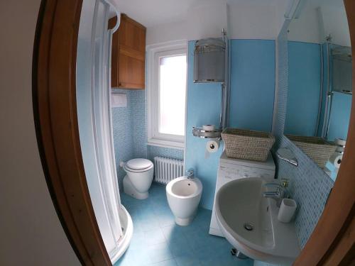 a blue bathroom with a toilet and a sink at Appartamento Dolonne Courmayeur in Courmayeur