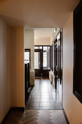 a hallway with a door and a tile floor at Hotel Amerika in Hoek van Holland