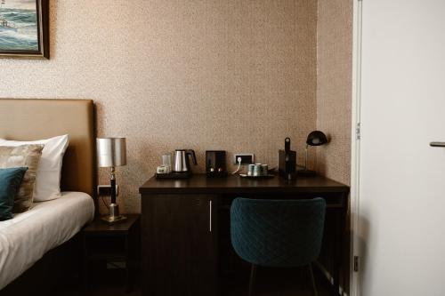 a bedroom with a bed and a desk with a chair at Hotel Amerika in Hoek van Holland