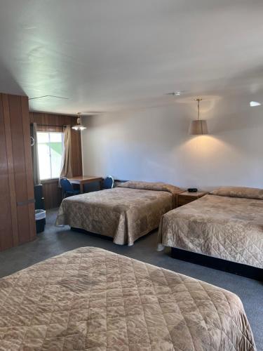um quarto de hotel com duas camas e uma janela em El Portal Motel em Beatty