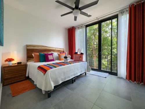 um quarto com uma cama e uma ventoinha de tecto em Casa Debra em Puerto Morelos