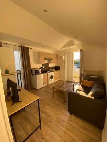 un salon avec un canapé et une table dans l'établissement Petit T2 proche centre ville, à La Roche-sur-Yon