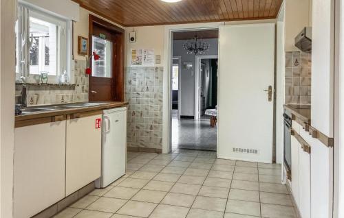 a kitchen with white cabinets and a tile floor at Cozy Home In Merkem With Wifi in Merkem