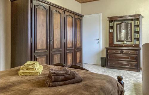 een slaapkamer met een bed en een dressoir met handdoeken erop bij Cozy Home In Merkem With Wifi in Merkem