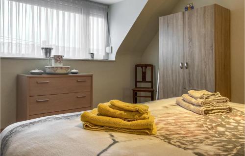 a bedroom with a bed with yellow towels on it at Cozy Home In Merkem With Wifi in Merkem