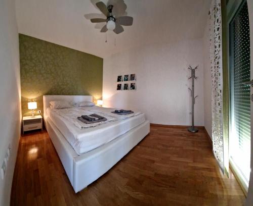 a bedroom with a white bed and a ceiling fan at Apartment MaDe in Petrcane