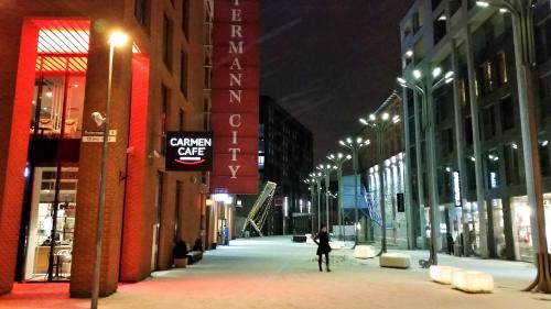 a person walking down a city street at night at Rotermanni Guest Apartments in Tallinn