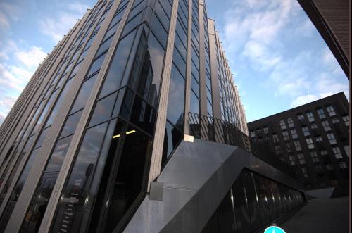 a tall building with glass windows in a city at Rotermanni Guest Apartments in Tallinn