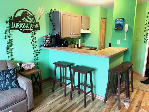 a kitchen with green walls and a bar with stools at Jurassic Dino Suite Jiminy-Must See Sleeps 4 in Hancock