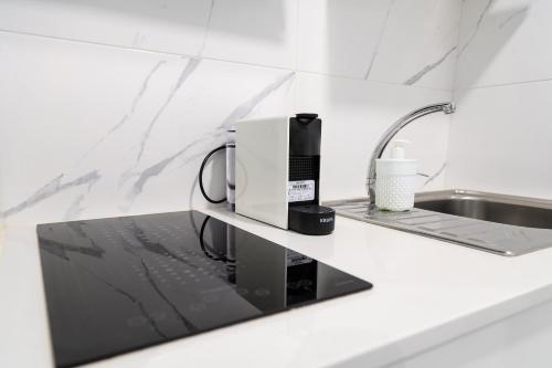 - un comptoir de cuisine avec une cafetière et un évier dans l'établissement Casa da Candida one place, many things, à Nazaré