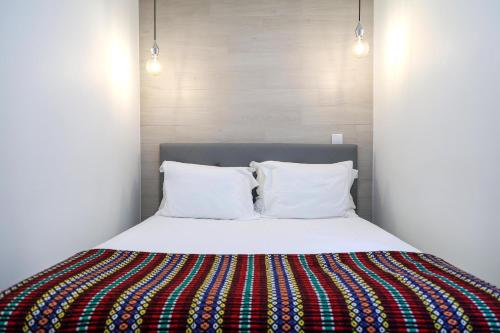 a bedroom with a bed with a colorful blanket on it at Casa da Candida one place, many things in Nazaré