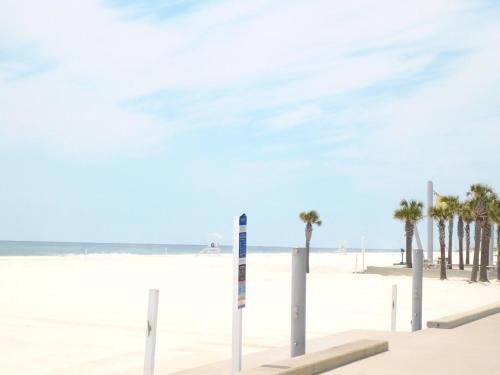 a beach with palm trees and the ocean at Budget Friendly Bungalow within Walking Distance to the Beach! in Gulf Shores