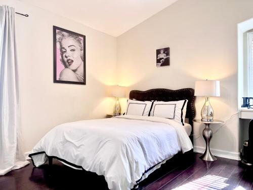 Hollywood Hills Homestay في لوس أنجلوس: غرفة نوم بسرير كبير عليها شراشف ووسائد بيضاء