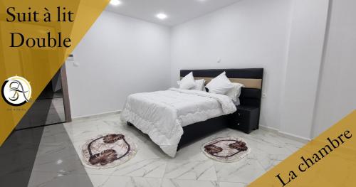 a bedroom with a bed with a white comforter at Hostel SA Bab Ezzouar in Le Lido