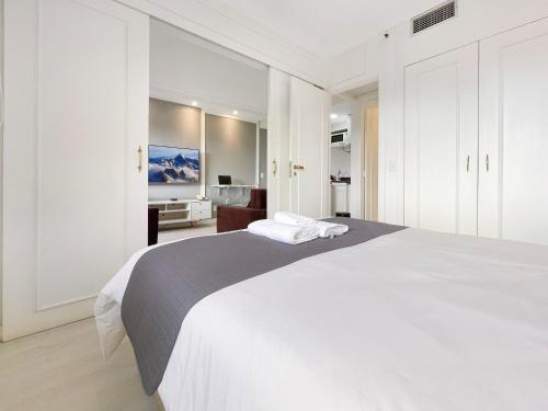 a white bedroom with a large bed with white cabinets at Hotel Completo no Itaim in Sao Paulo