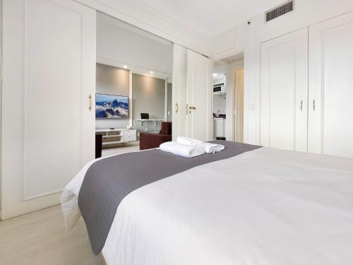 a white bedroom with a large bed with white cabinets at Hotel Vila Olimpia Cozinha Piscina Academia in Sao Paulo