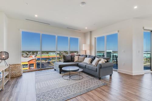 a living room with a couch and large windows at Glamorous 5 BR Condo right next to The Hangout! in Gulf Shores