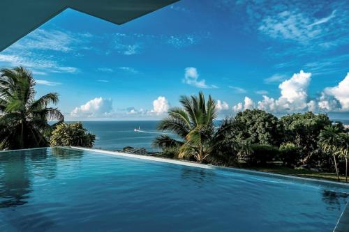una piscina con el océano en el fondo en Grand Large - Premium suite, en Papeete