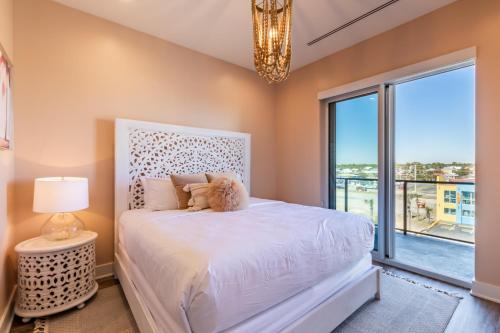 a bedroom with a white bed and a large window at Glamorous 5 BR Condo right next to The Hangout! in Gulf Shores