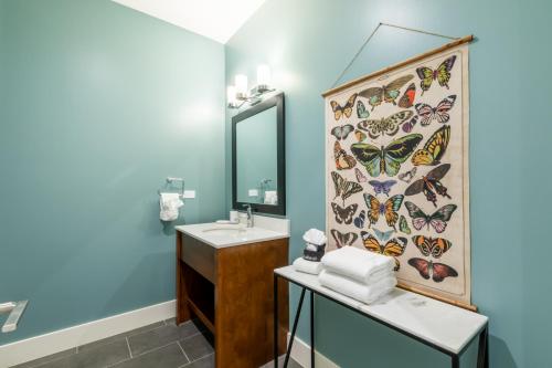 a bathroom with a mirror and a sink with butterflies on the wall at Glamorous 5 BR Condo right next to The Hangout! in Gulf Shores