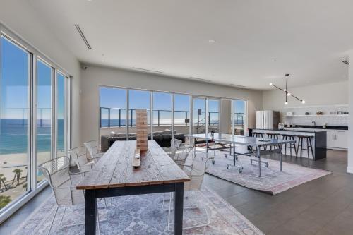 a dining room with a table and chairs and the ocean at Glamorous 5 BR Condo right next to The Hangout! in Gulf Shores